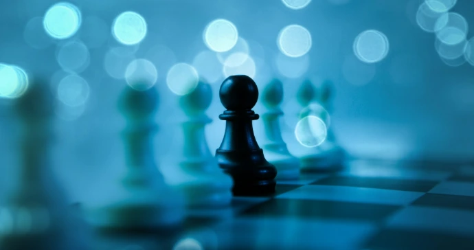 A black pawn stands out on a chessboard.